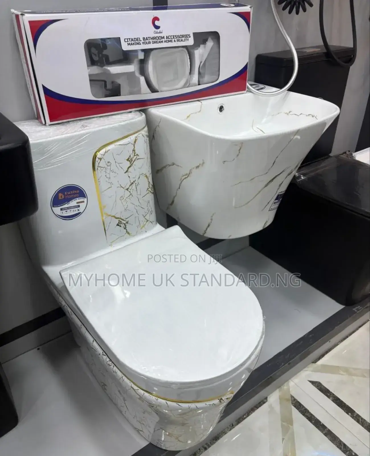 White Toilet With a Marble-Patterned Tank and Hanging Basin
