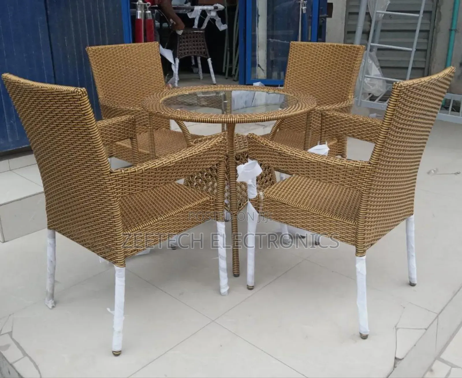 Black Rattan Outdoor Dining Set With a Glass-Top Table and Four Armcha