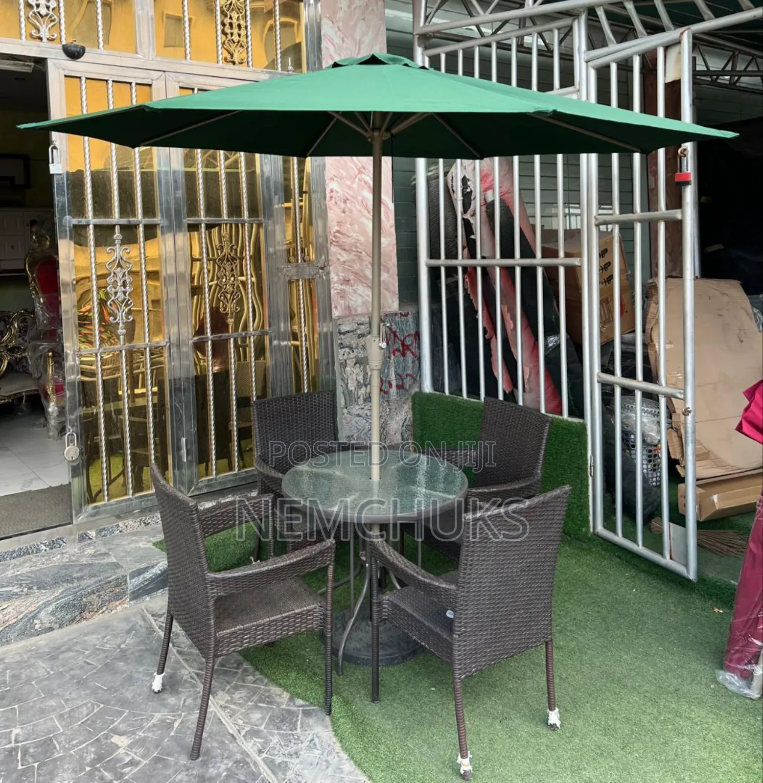 Outdoor Chairs and Round Glass-Top Table With a Large Umbrella