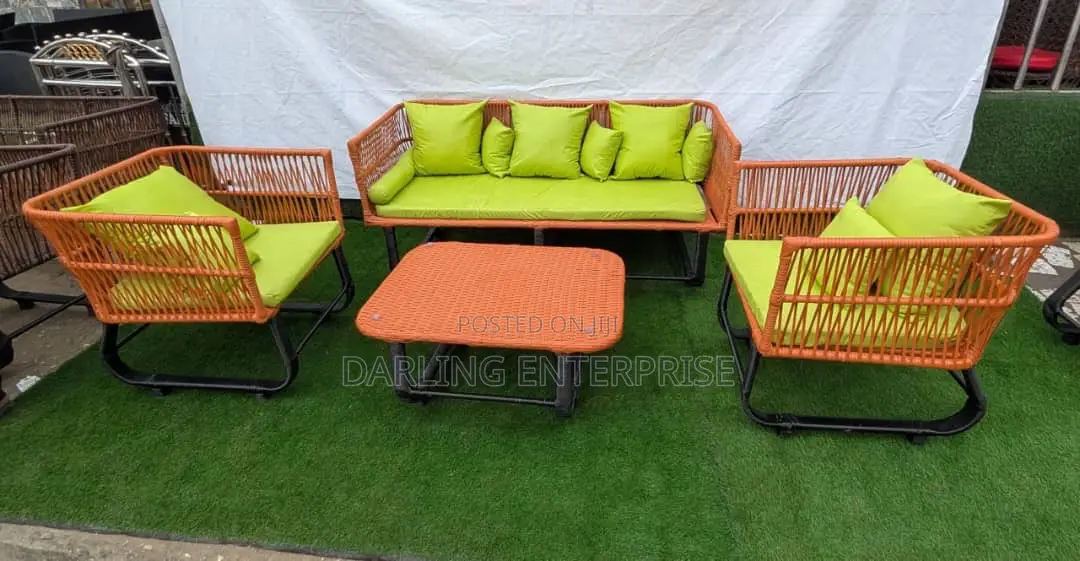 Orange Rattan Sofa Set Features Green Cushions for Outdoor Seating.