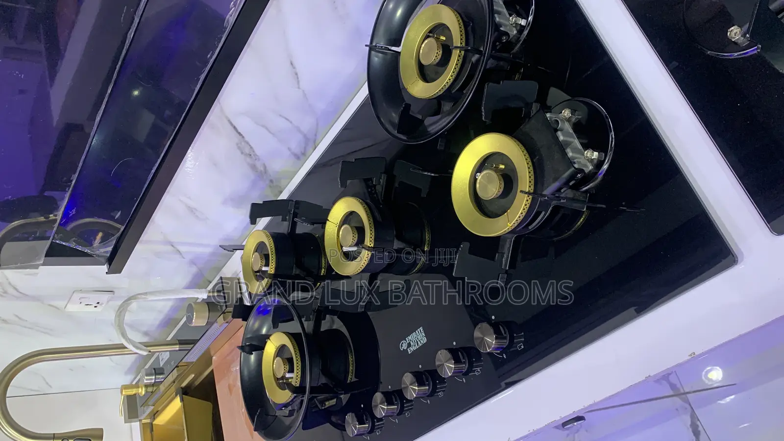 A Modern Black Gas Hob With Five Gold-Accented Burners