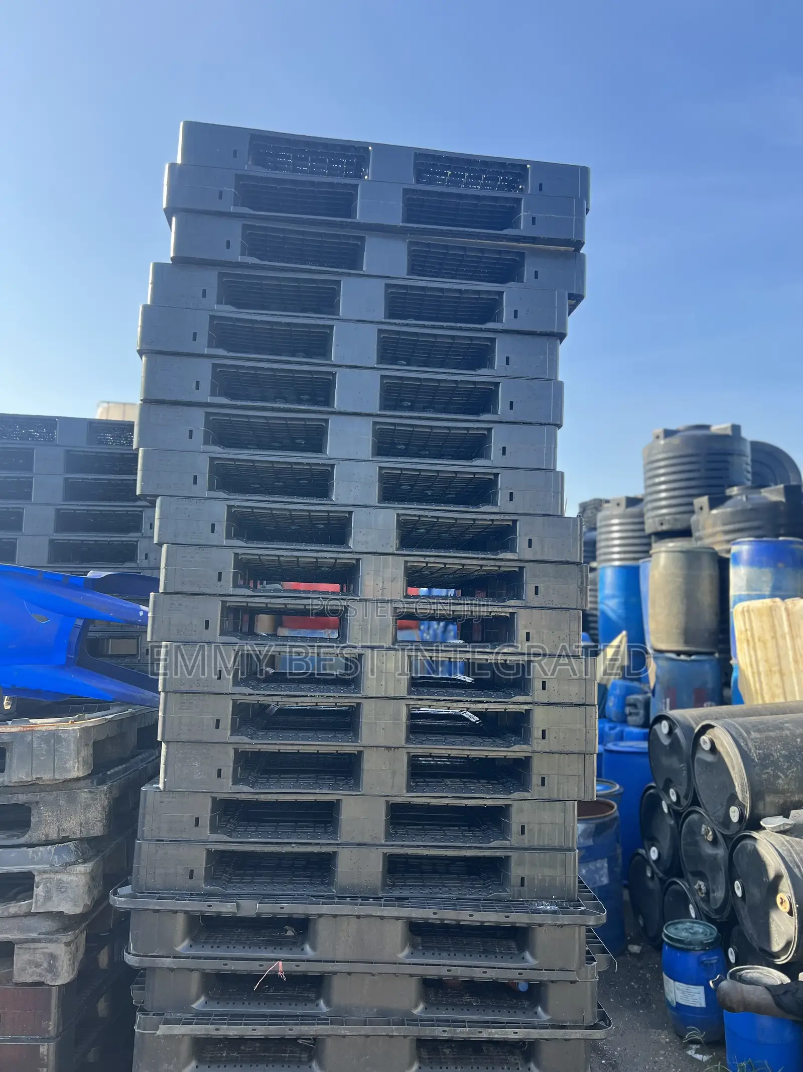 Tall Stack Of Black Plastic Pallets.