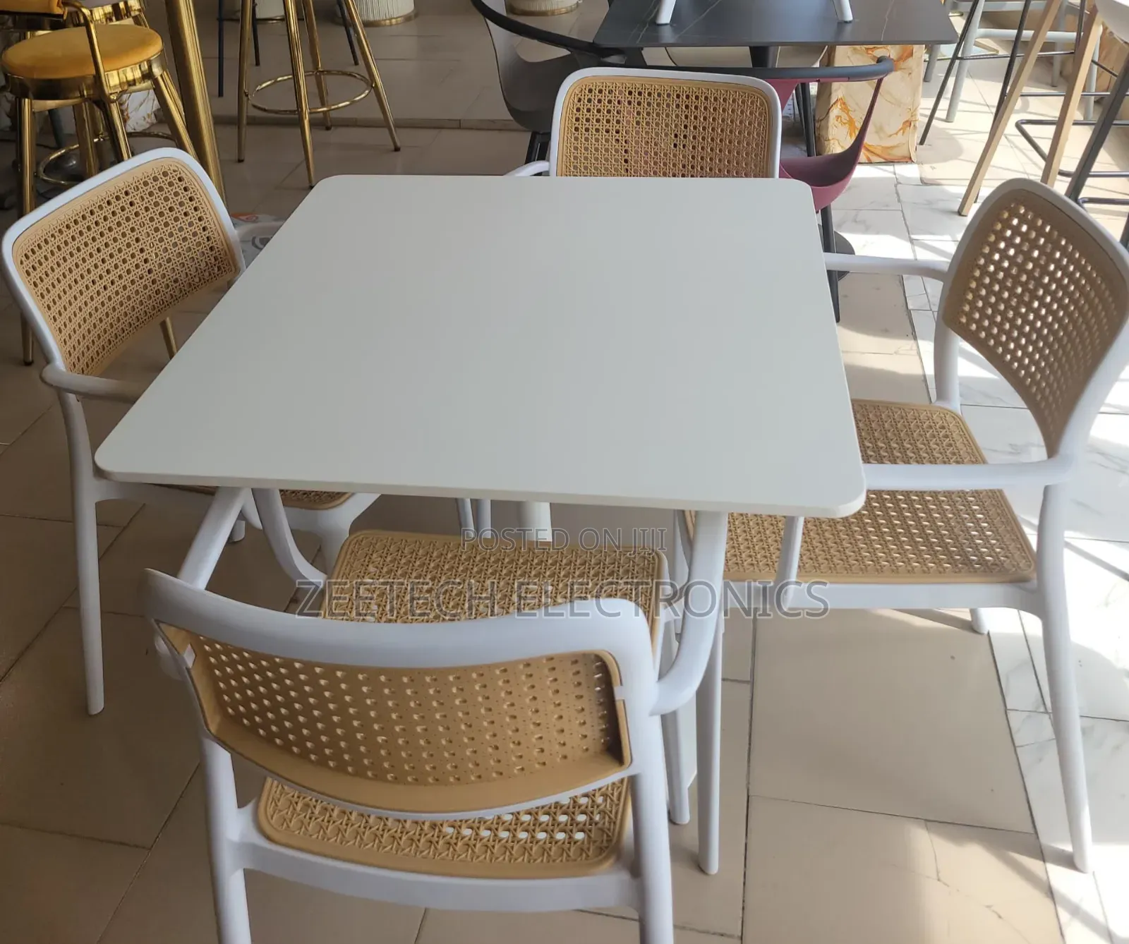 Beige Dining Set With a Square Table and Four Chairs.