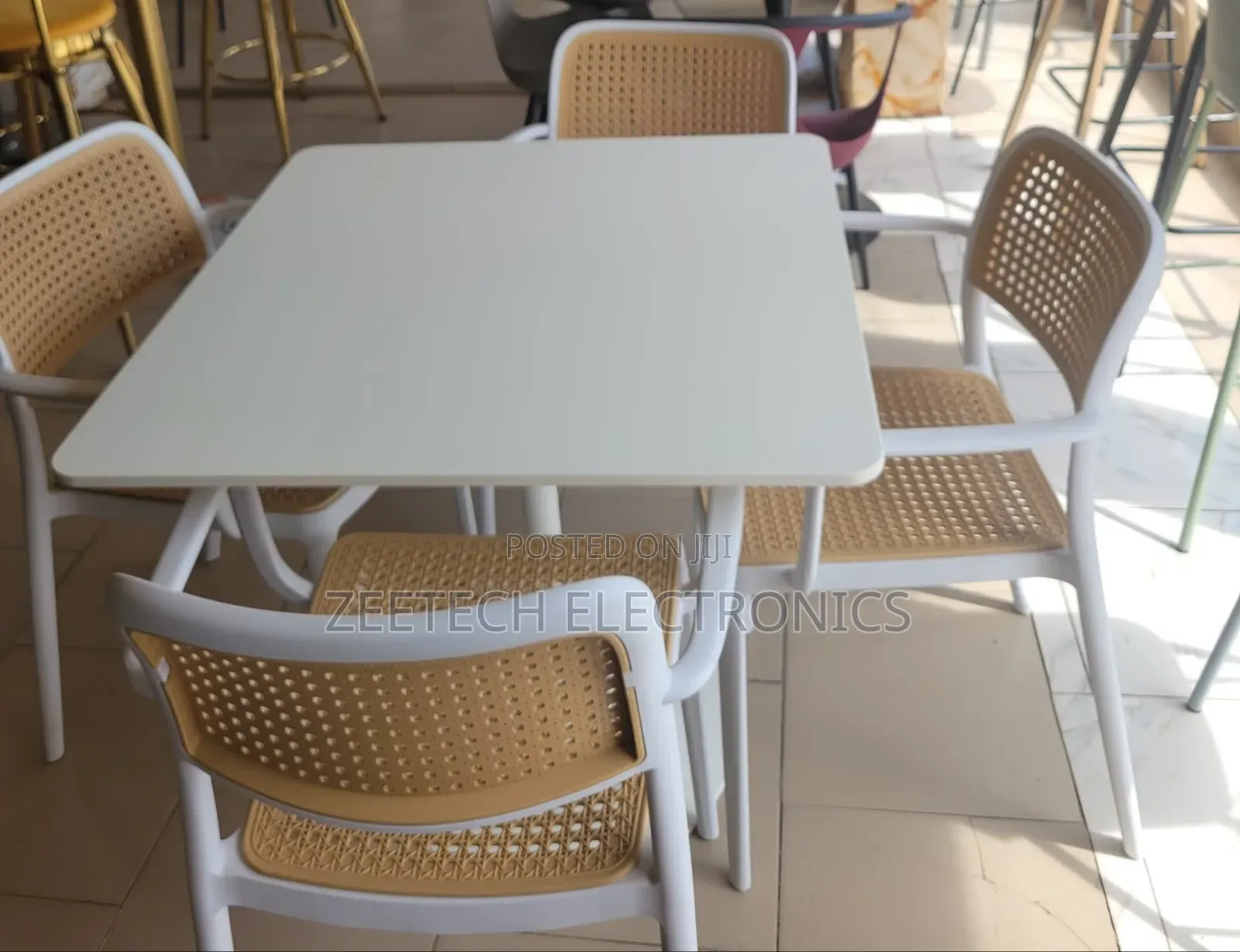Beige Dining Set With a Square Table and Four Chairs.