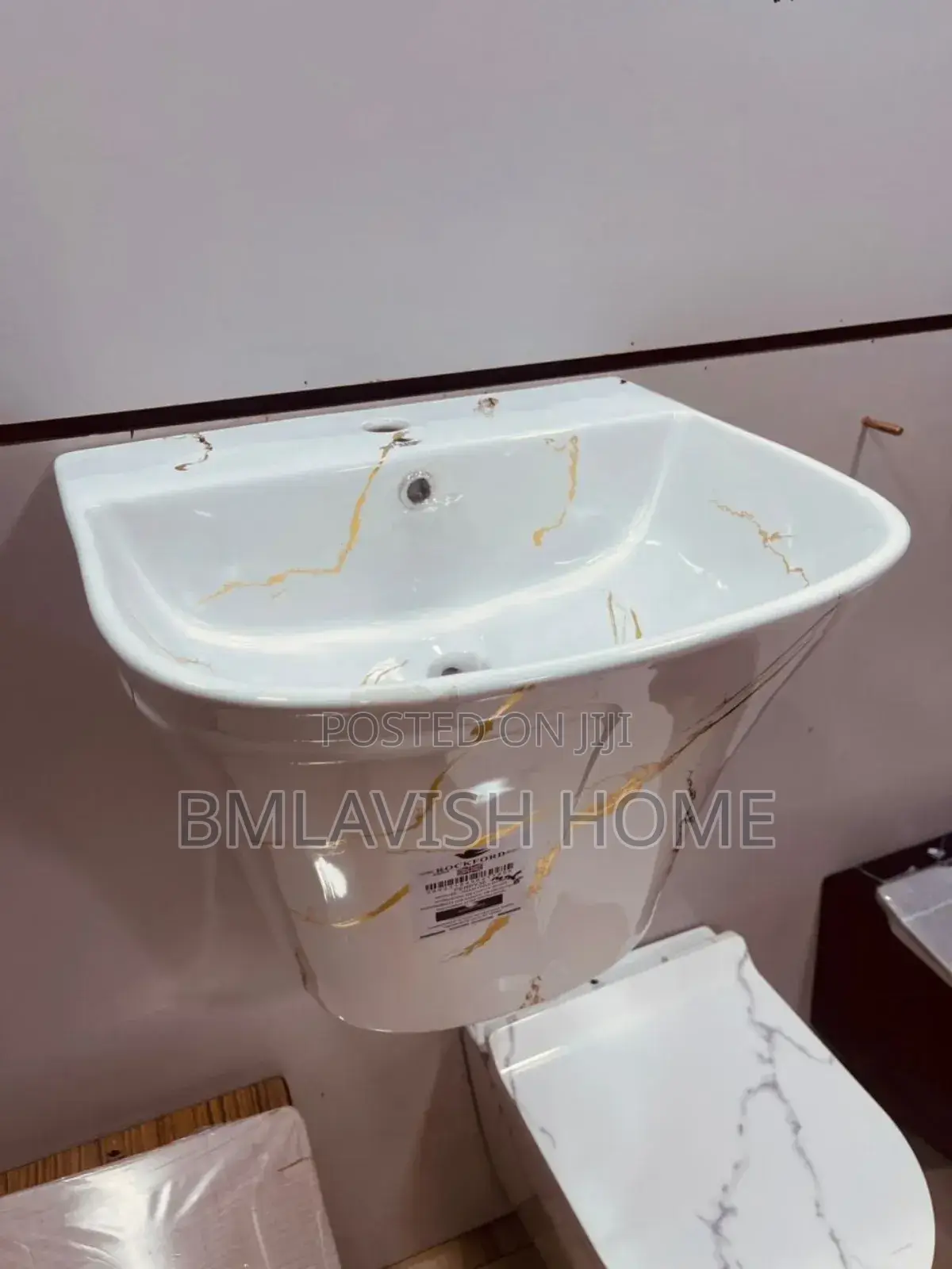 Wall-Mounted Wash Basin With a White and Gold Marble-Style Finish.