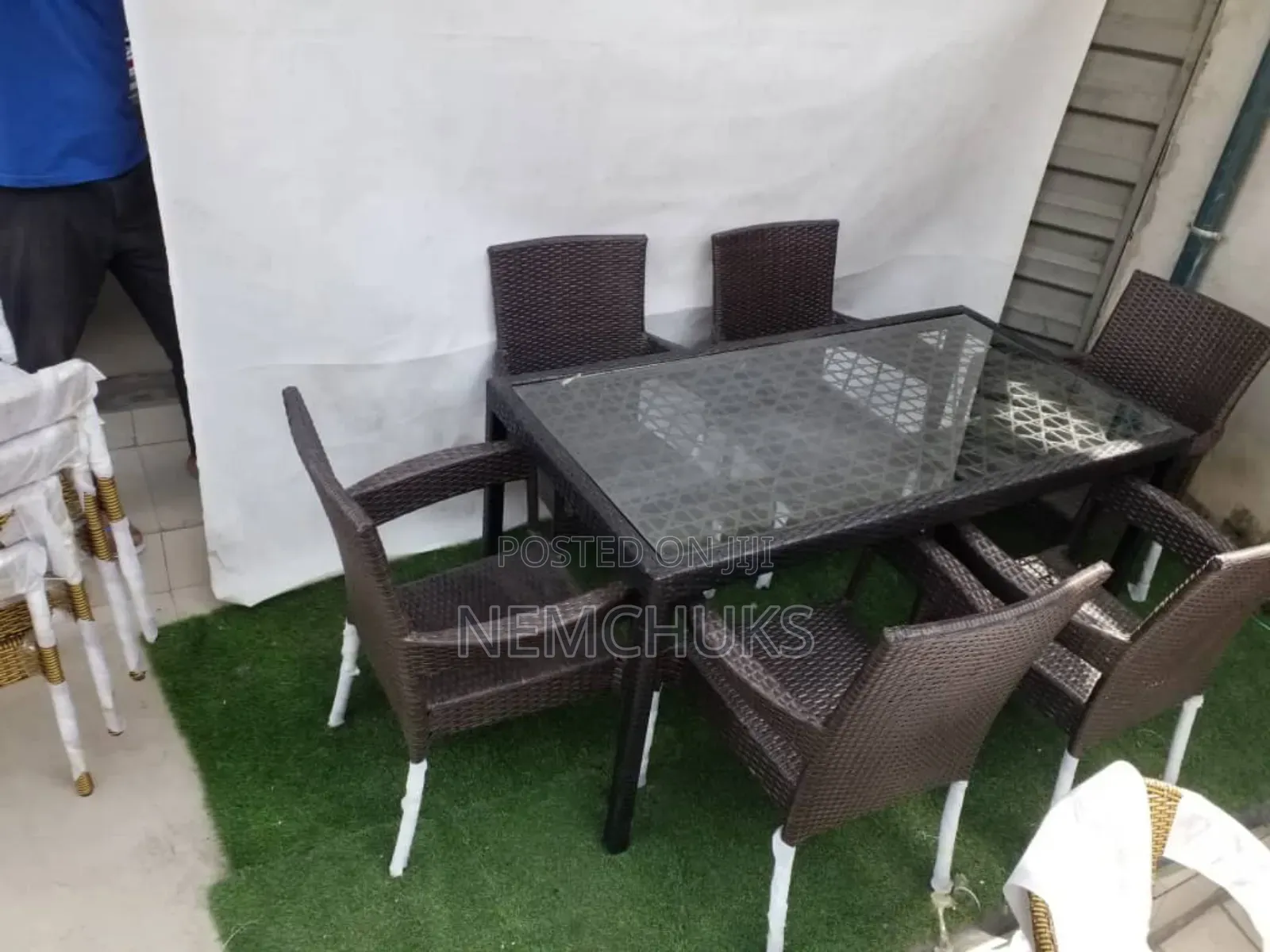 A Synthetic Rattan Outdoor Dining Set With a Glass-Top Table