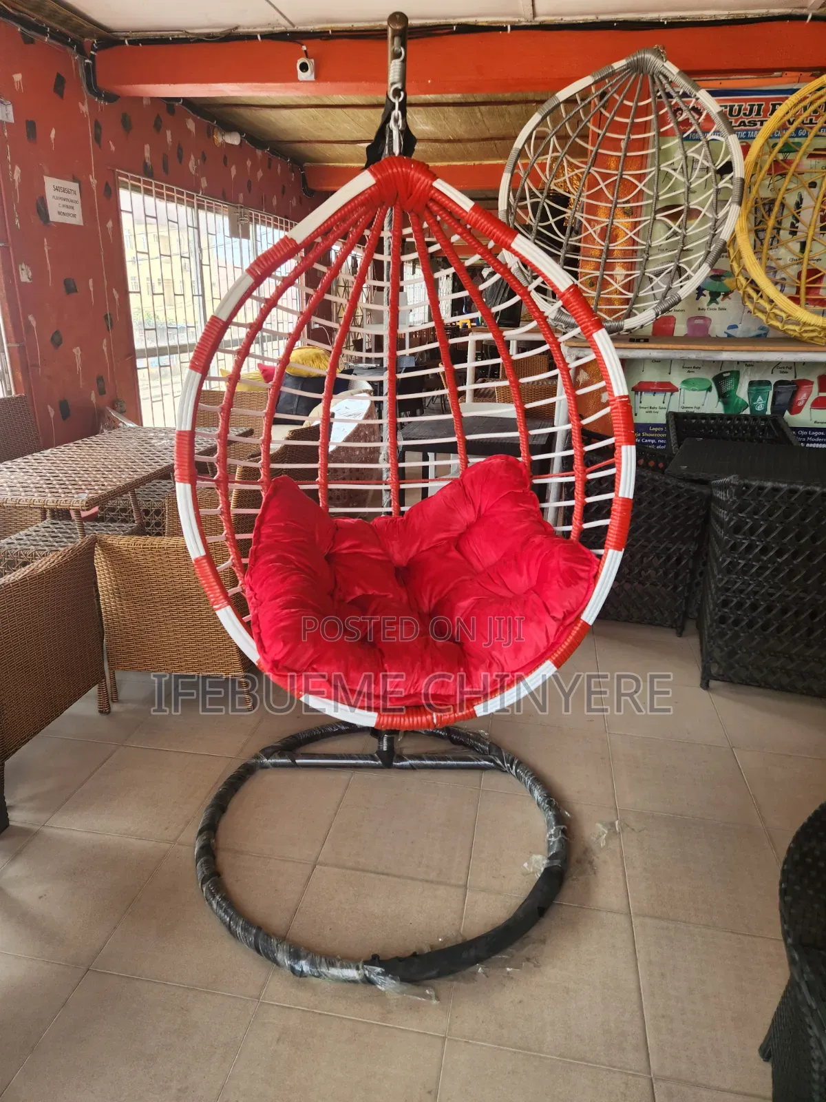 Red and White Swinging Chair With Red and Black Cushion