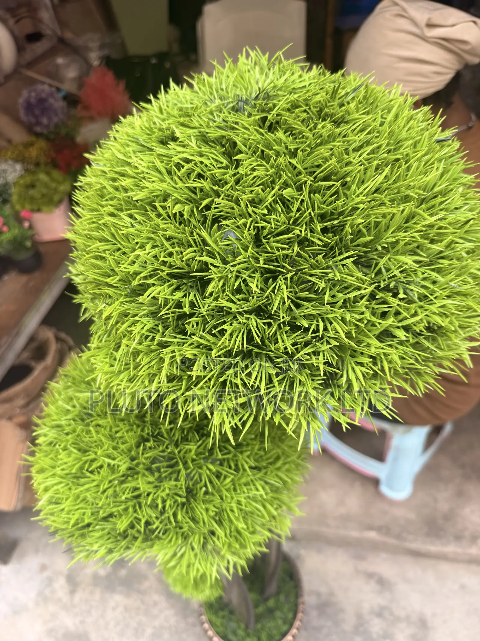 This Artificial Topiary Tree Features Multiple Tiered Green