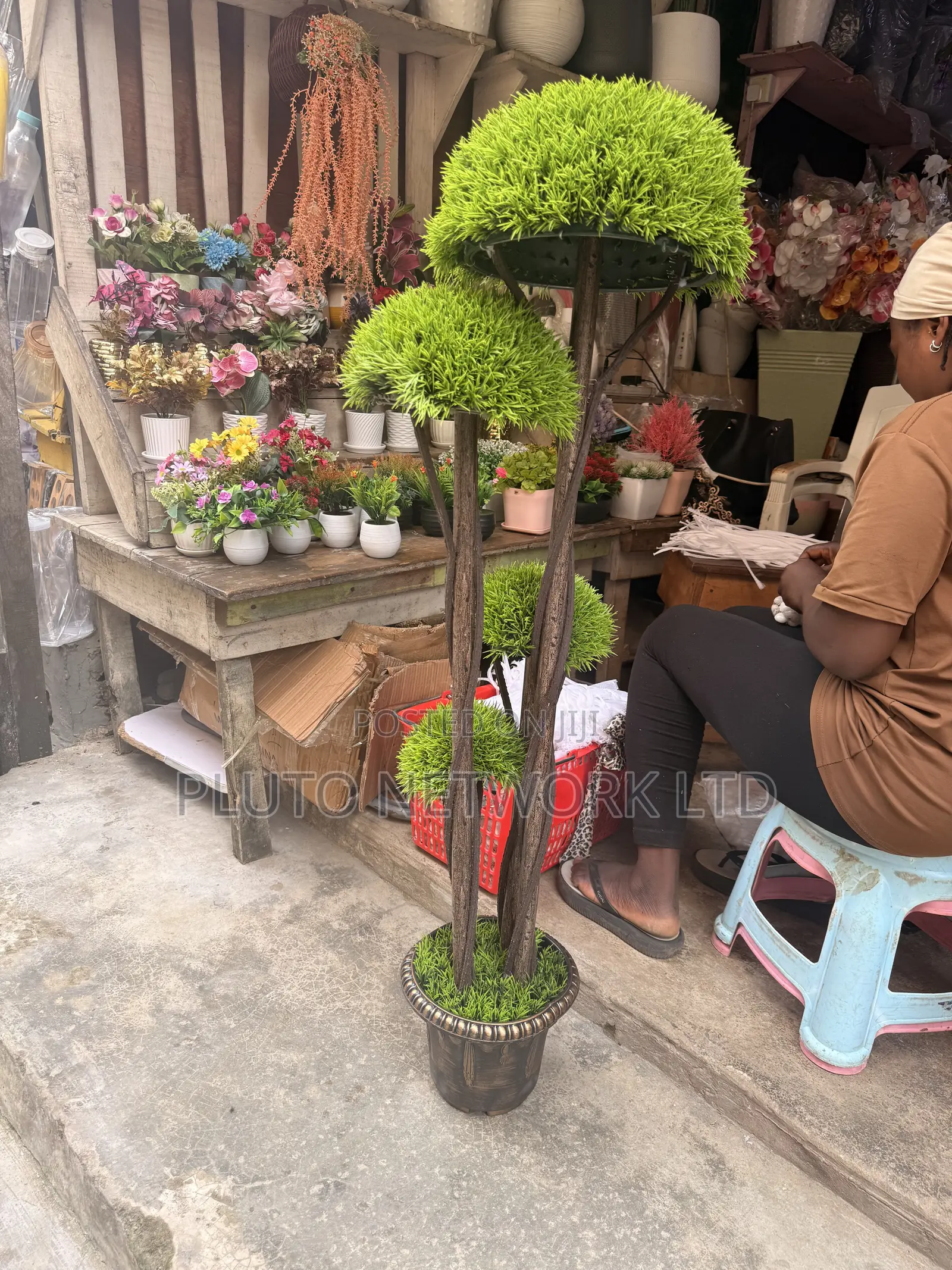 This Artificial Topiary Tree Features Multiple Tiered Green