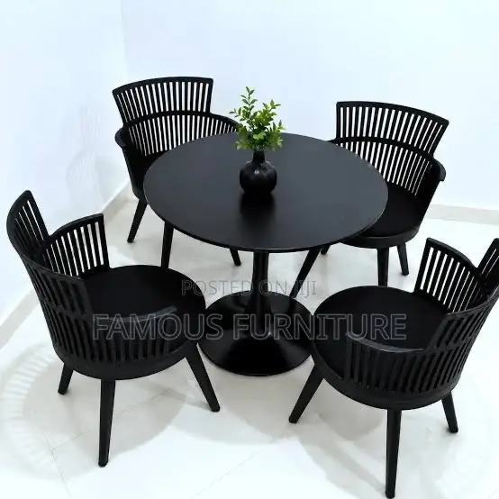 The Image Shows a Black Round Dining Table Set With Four Matching