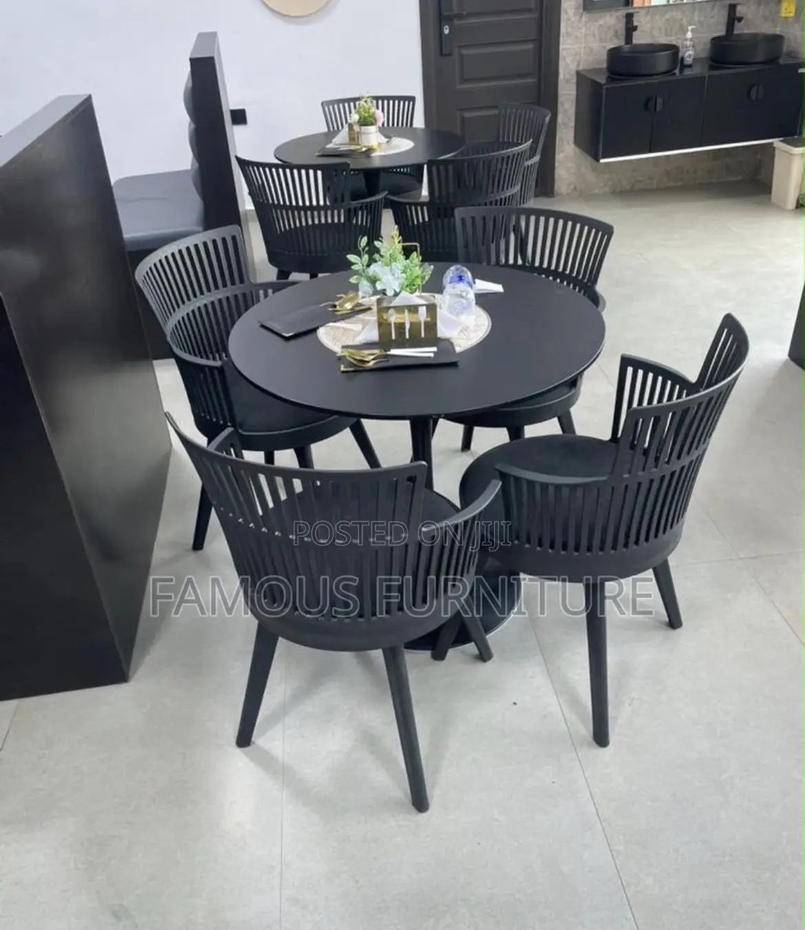 The Image Shows a Black Round Dining Table Set With Four Matching