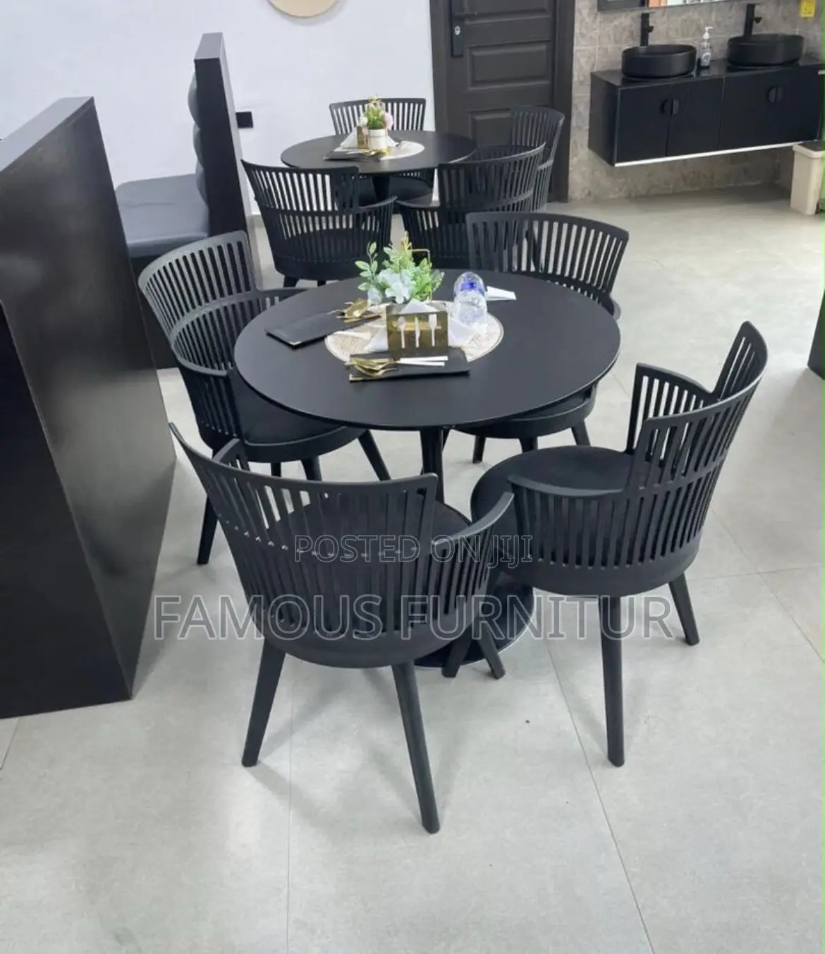 The Image Shows a Black Round Dining Table Set With Four Matching