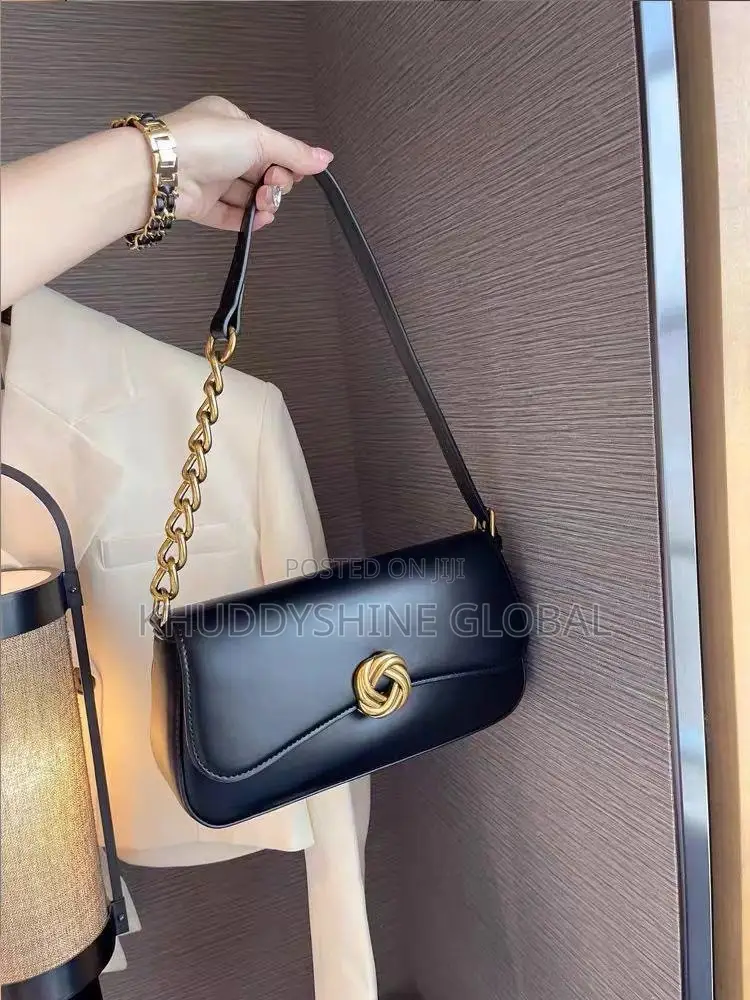 Leather Baguette Shoulder Bag Features a Distinctive Gold-Toned Twist