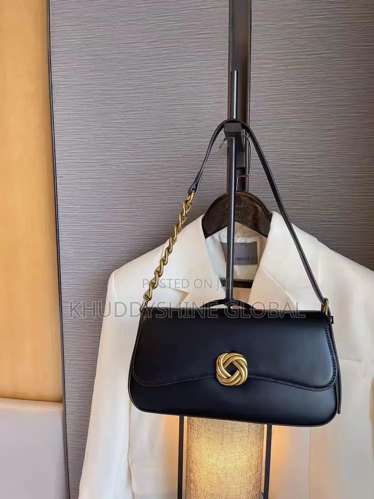 Leather Baguette Shoulder Bag Features a Distinctive Gold-Toned Twist