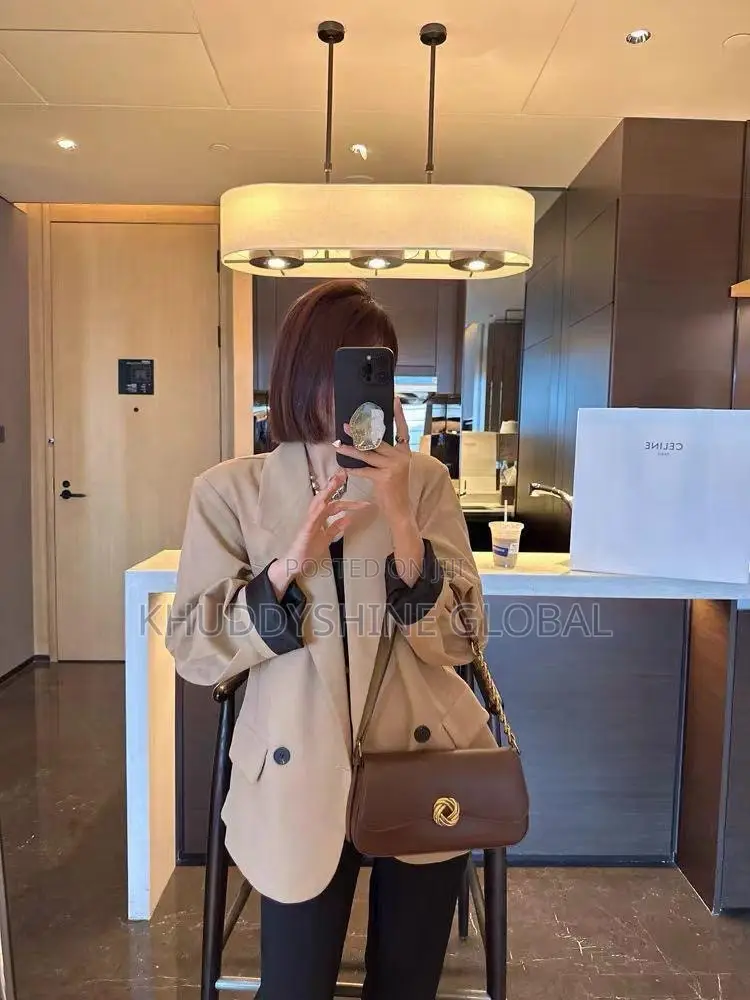 Leather Baguette Shoulder Bag Features a Distinctive Gold-Toned Twist