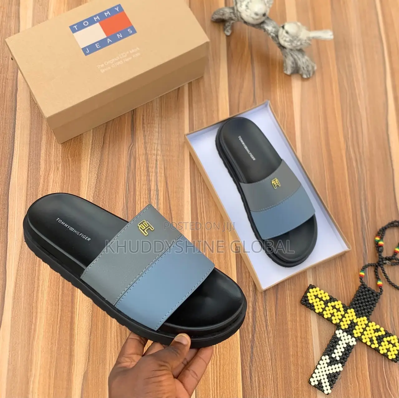 Men's Designer-Style Slip-on Sandals and Slides Arranged on a Wooden