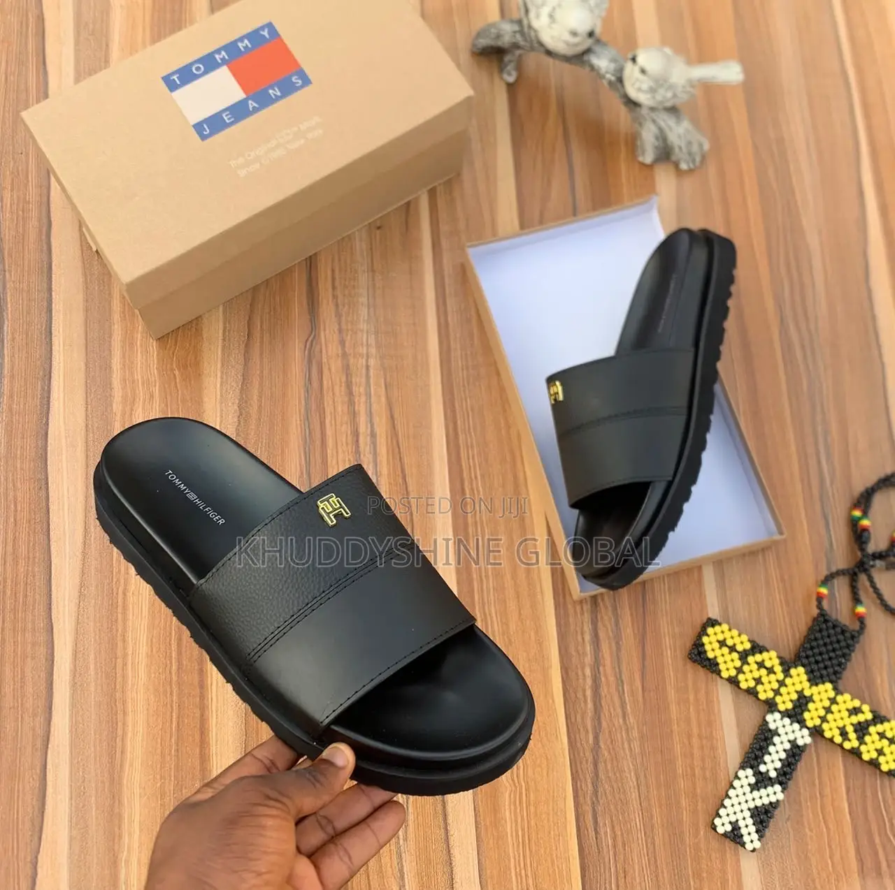 Men's Designer-Style Slip-on Sandals and Slides Arranged on a Wooden