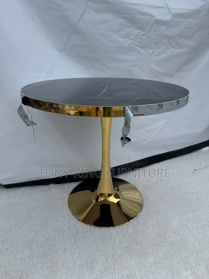 Modern Round Table With a Dark, Faux-Marble Top and a Shiny Gold Base