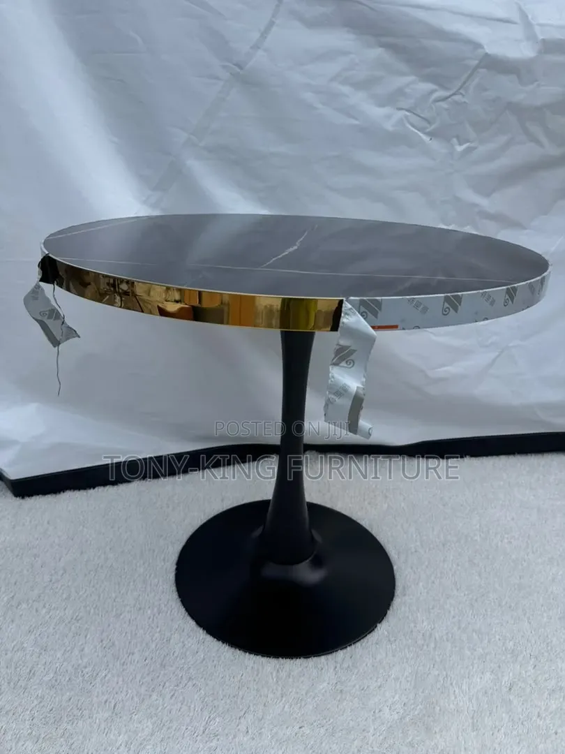 Modern Round Table With a Dark, Faux-Marble Top and a Shiny Gold Base