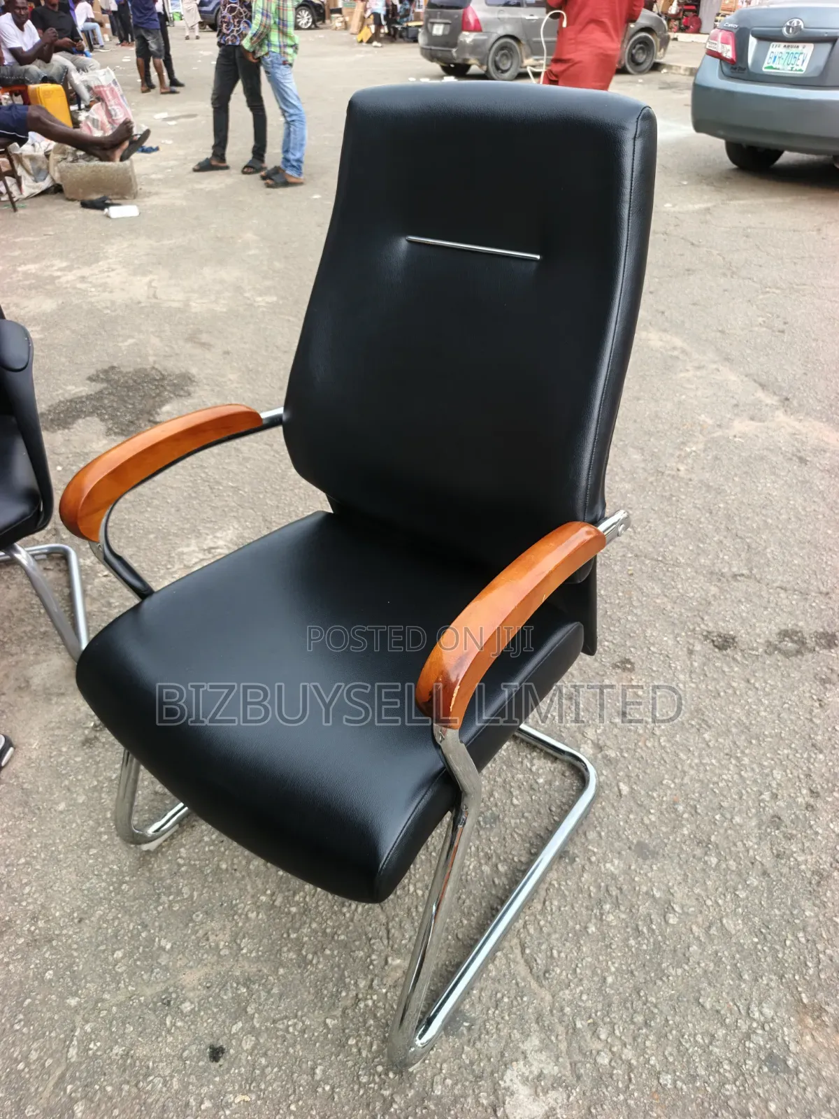 Black Leather Visitor Office Chair Featuring Polished Wooden Armrests.