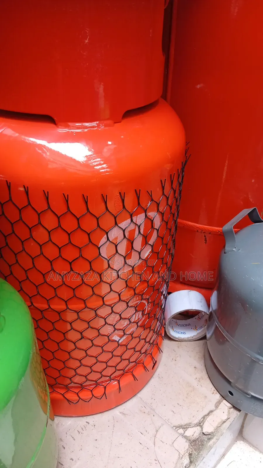 12.5 Kg LPG Cooking Gas Cylinder Wrapped in a Protective Mesh Net.