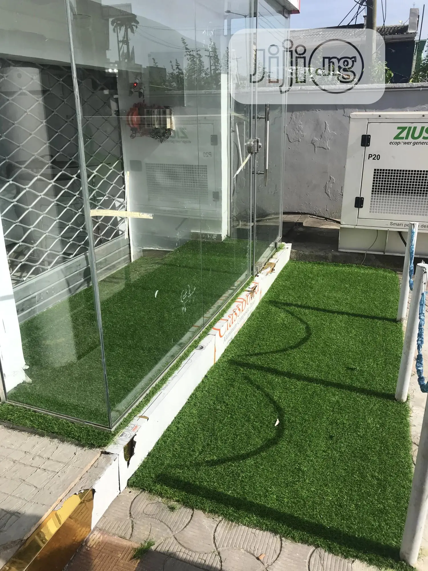 Decoration Of Your Show Room Entrance With Green Grass Rugs